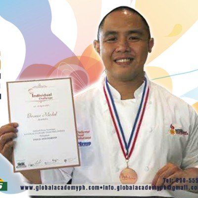 Man holding a certificate and wearing a medal, smiling against a colorful background.
