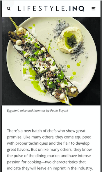 Top-down photo of a plated gourmet salad with avocado, greens, and seeds on a white plate