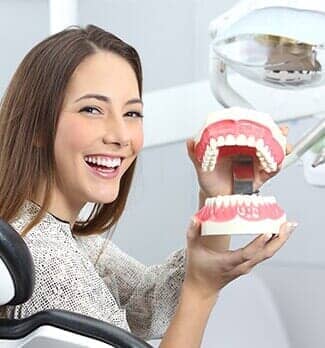 Dentist patient smiling with a plastic denture — Dental Office in Virginia Beach, VA Dentist patient smiling with a plastic denture — Dental Office in Virginia Beach, VA