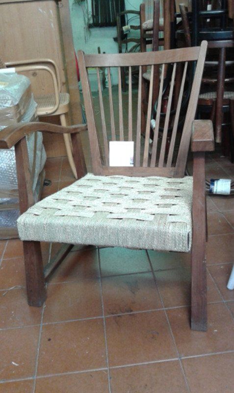 chair with arched back and a straw seat with complex textures