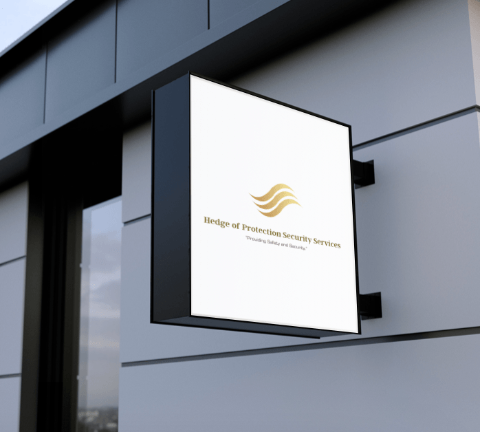 White illuminated wall sign with gold logo on a gray building exterior