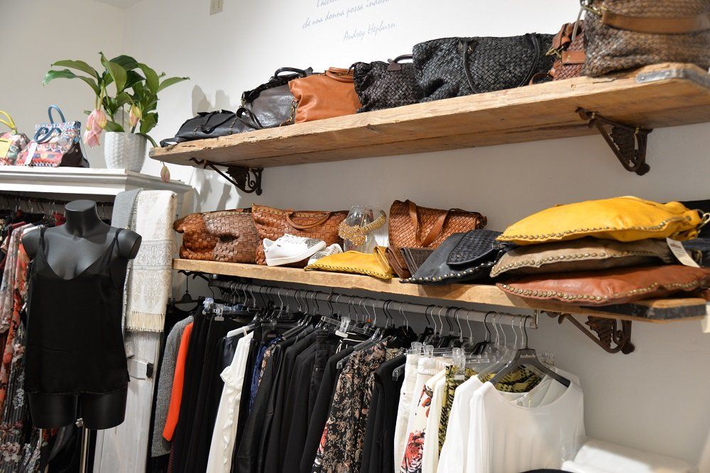 Ripiano dell'armadio con scarpe, giacche e vestiti assortiti appesi al di sotto