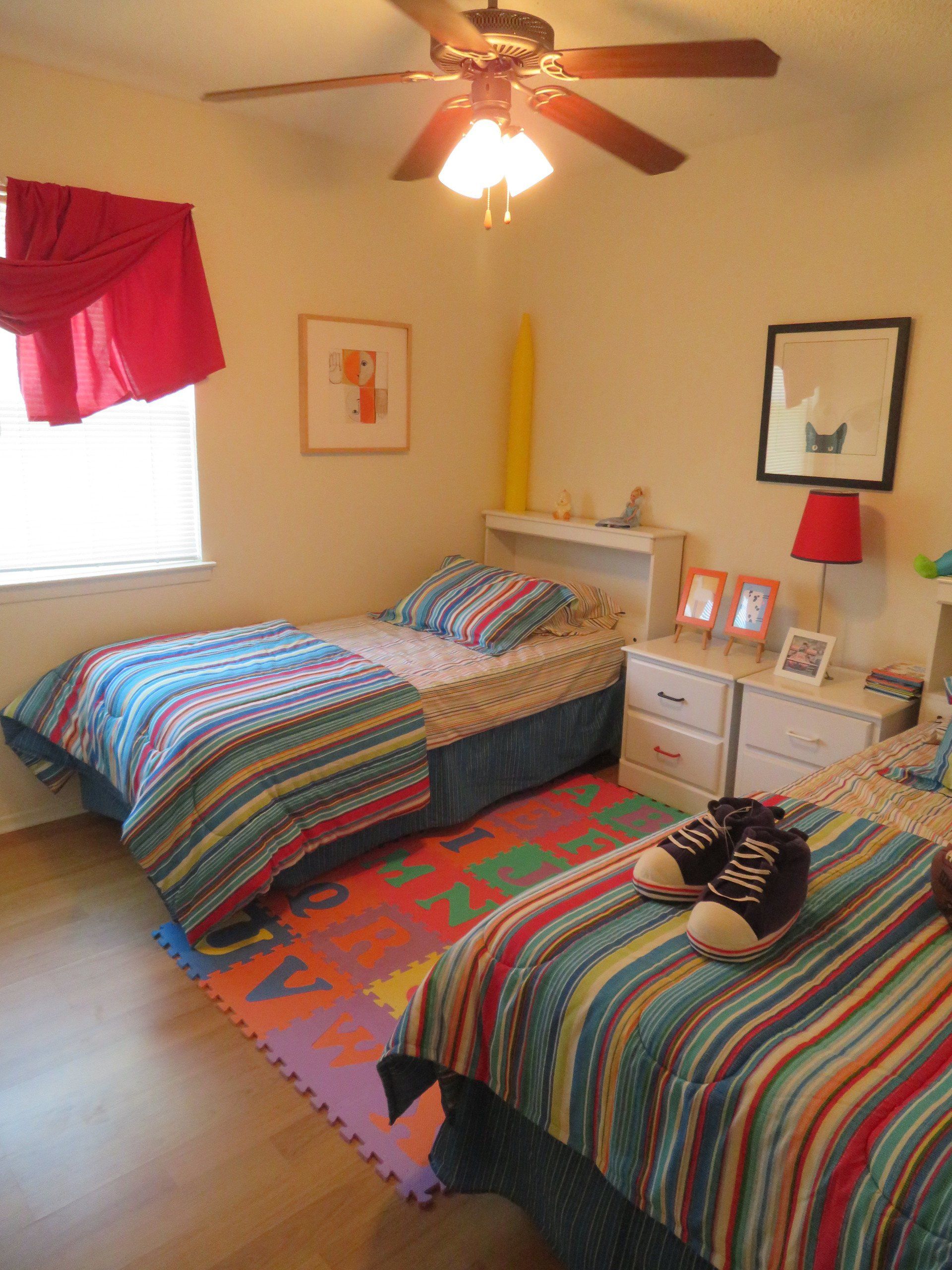 One of Lions Court Apartments 2 bedrooms with two beds and a ceiling fan with hardwood laminate flooring