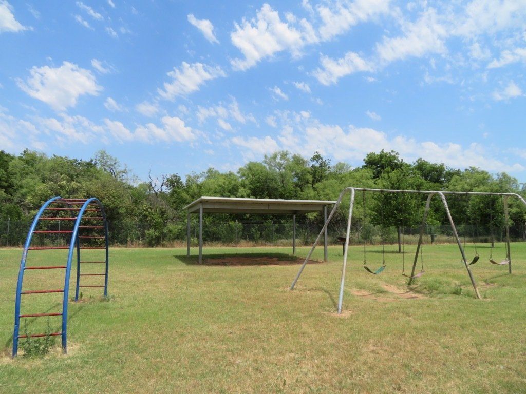 Covered BBQ & outdoor activity areas in a grassy field at lions court apartments in Wichita Falls, TX