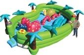 A man is standing on top of a green inflatable slide.