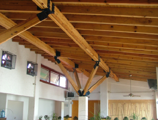 Techo con vigas de madera en una habitación luminosa con paredes blancas, ventanas pequeñas y lámparas colgantes.