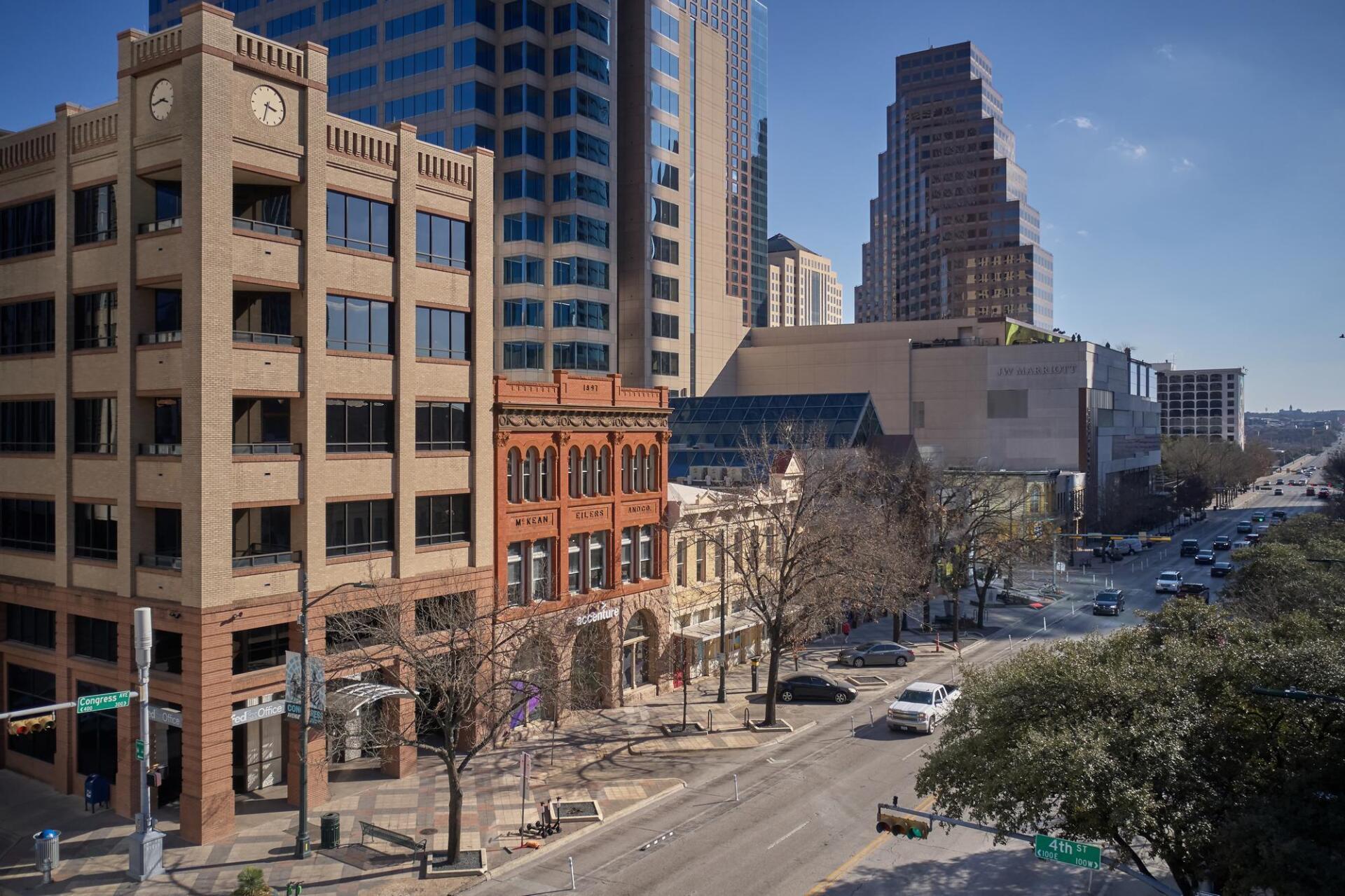 Downtown Austin cityscape with buildings, street, and traffic. Sunny day, modern and historic architecture.