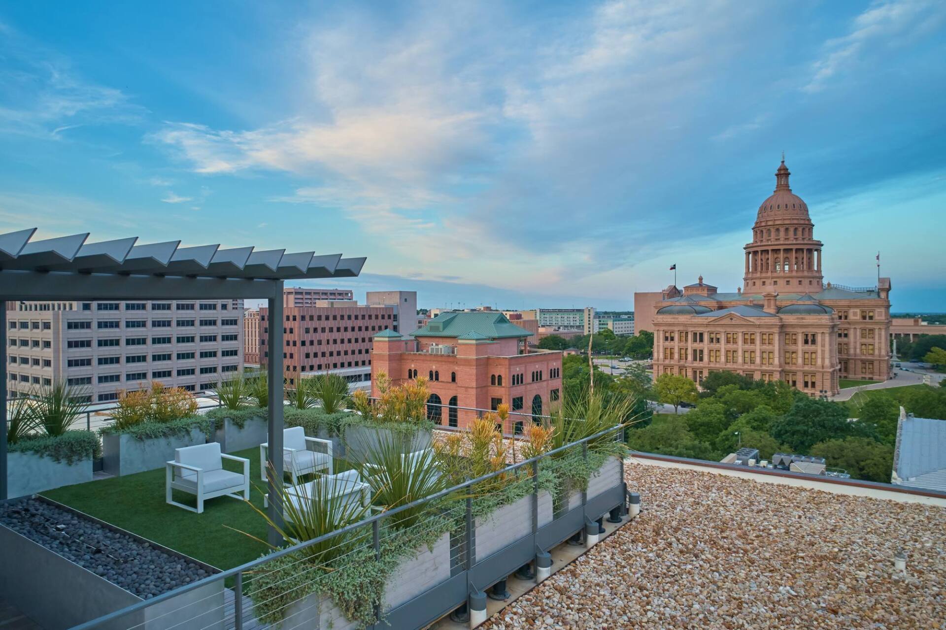 Rooftop patio overlooking Austin, Texas skyline with state capitol building in the distance.