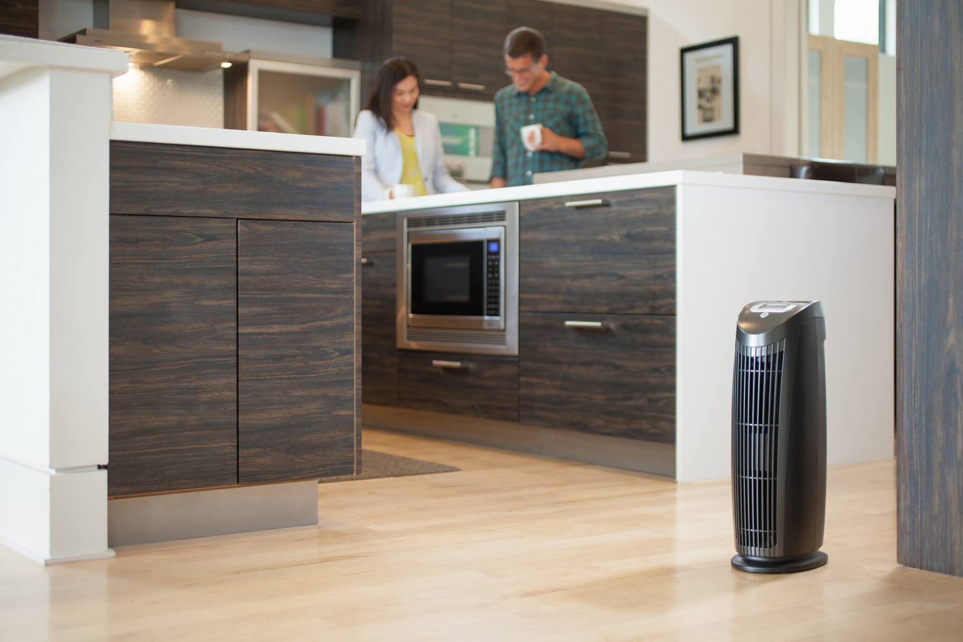 Air purifier in kitchen with couple standing near countertop.