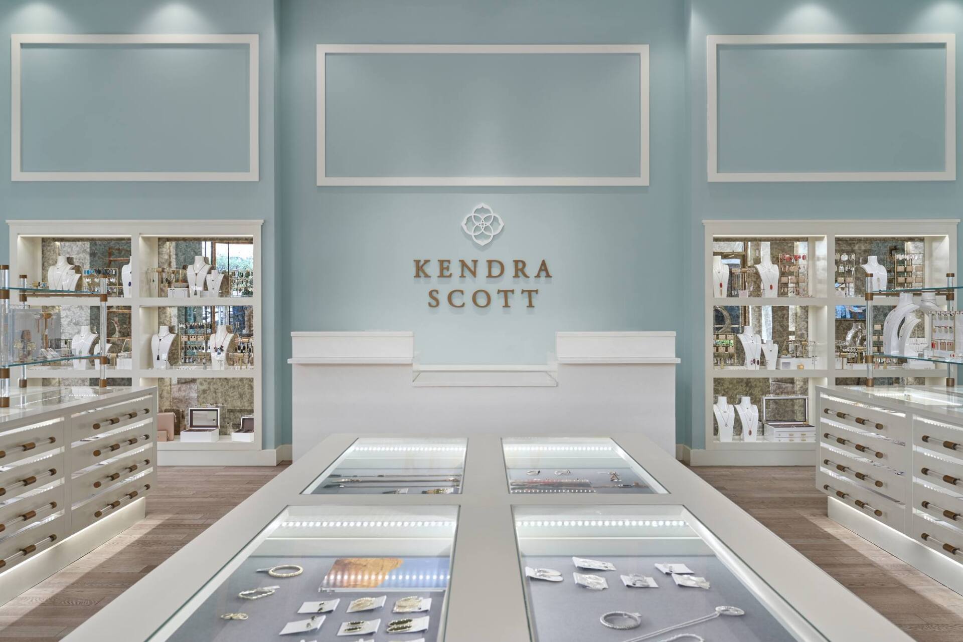 Kendra Scott jewelry store interior with display cases, light blue walls, and the company logo.