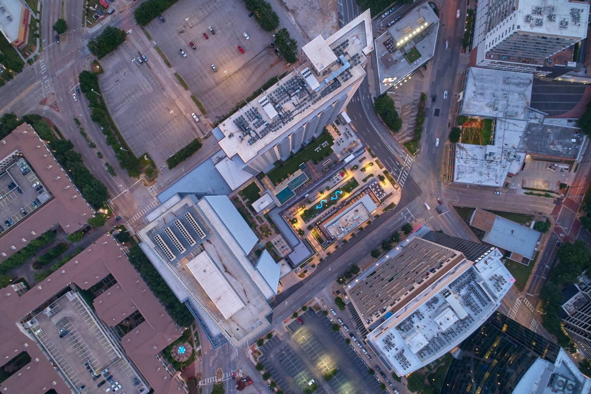 Aerial view of city buildings and streets at dusk.