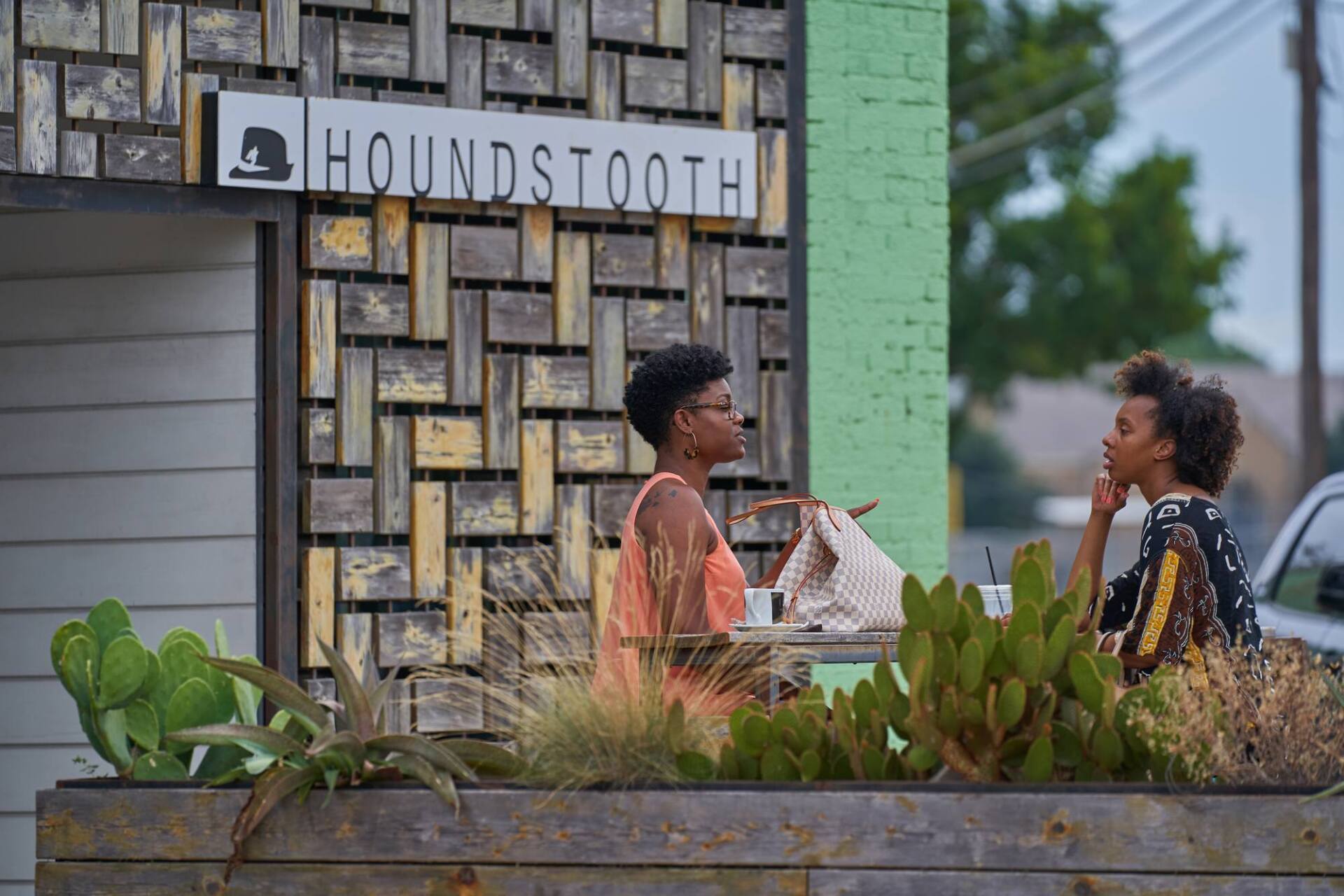 Two people talking at a table outside 