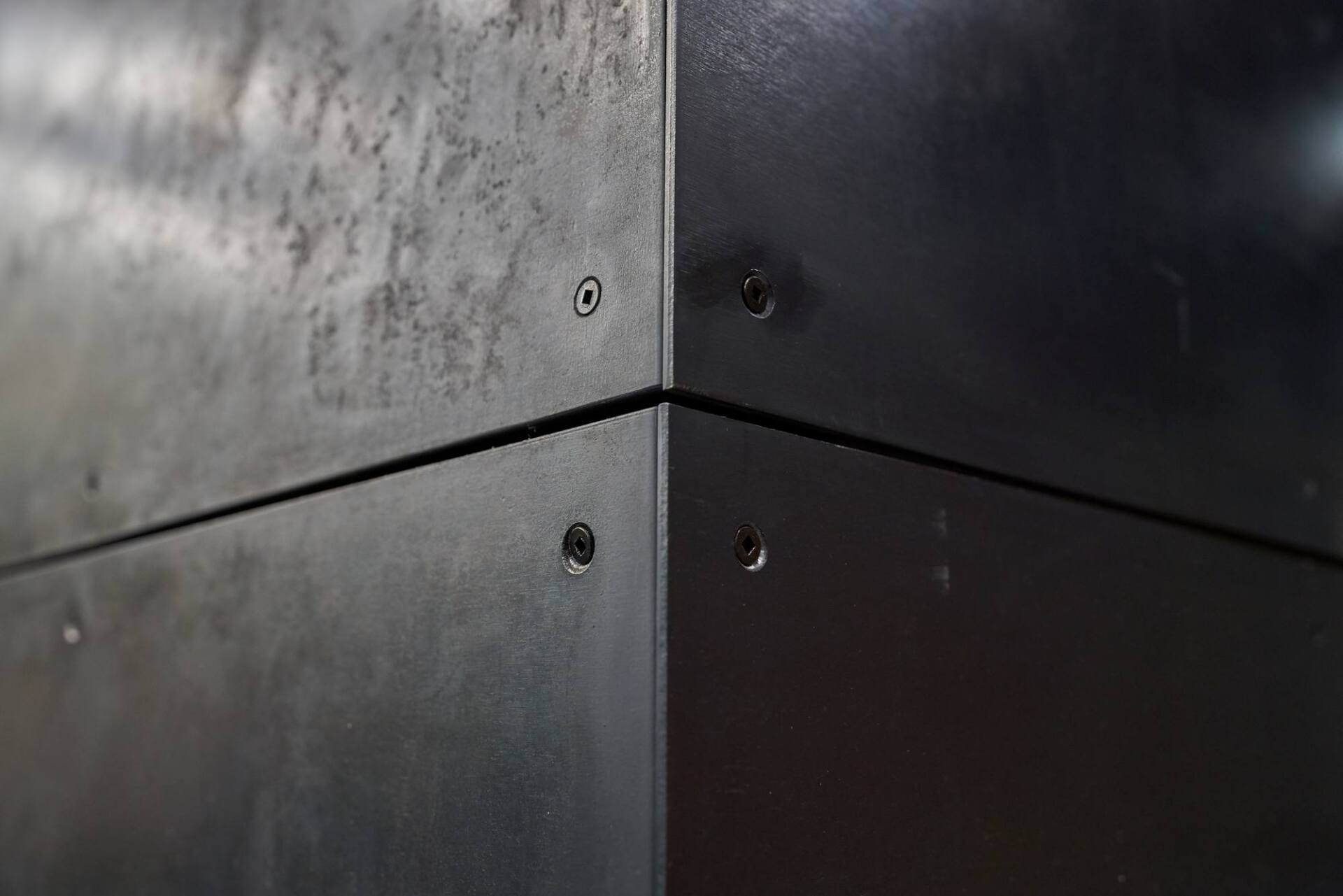Corner of metallic panels, with screws holding them together.