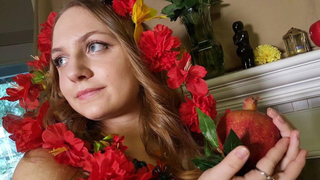 Woman with red flowers and a pomegranant, representing Persephone.