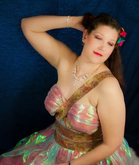 Woman posing in a pink dress, representing Aphrodite.