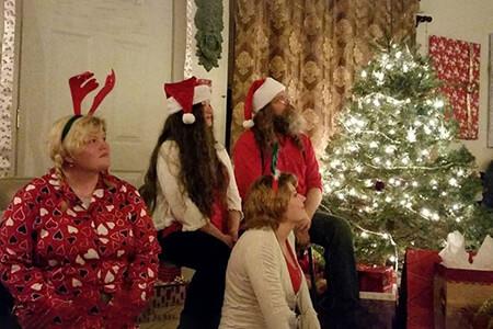 A group of people are sitting in front of a Yule tree,  members of the Aquarian Tabernacle Church.