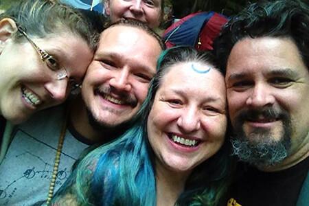 A group of people are posing for a picture together and smiling, members of the Aquarian Tabernacle Church.