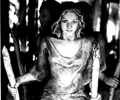 A black and white photo of a statue of a woman holding a candle.