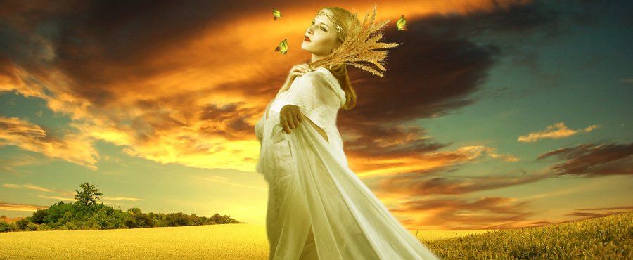 A woman in a white dress is standing in a field at sunset, representing Demeter.