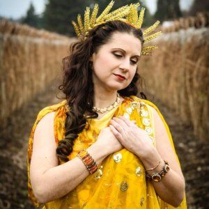 A woman in a yellow dress with a crown on her head,  representing Demeter.