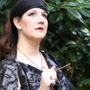 A woman holding a key with the number 13 on it, representing Hekate.