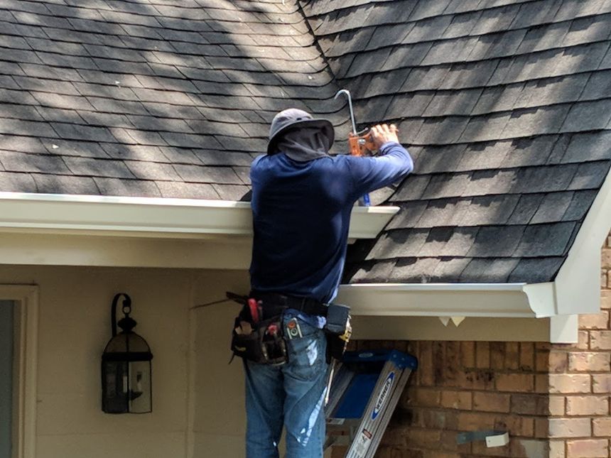 A man is working on the roof of a house.