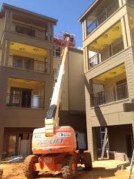 A construction vehicle is parked in front of a building under construction.