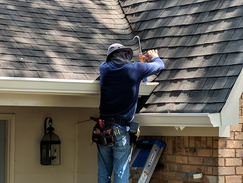 A man is working on the roof of a house.
