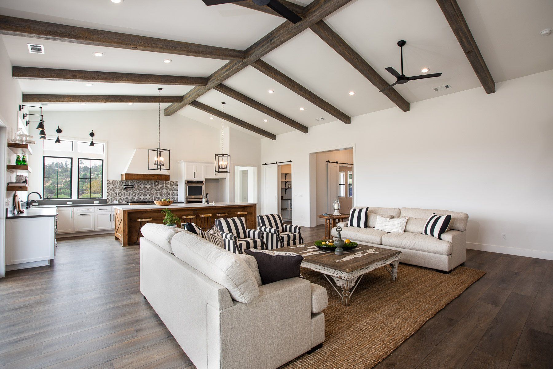A living room with two couches , a coffee table and a ceiling fan.