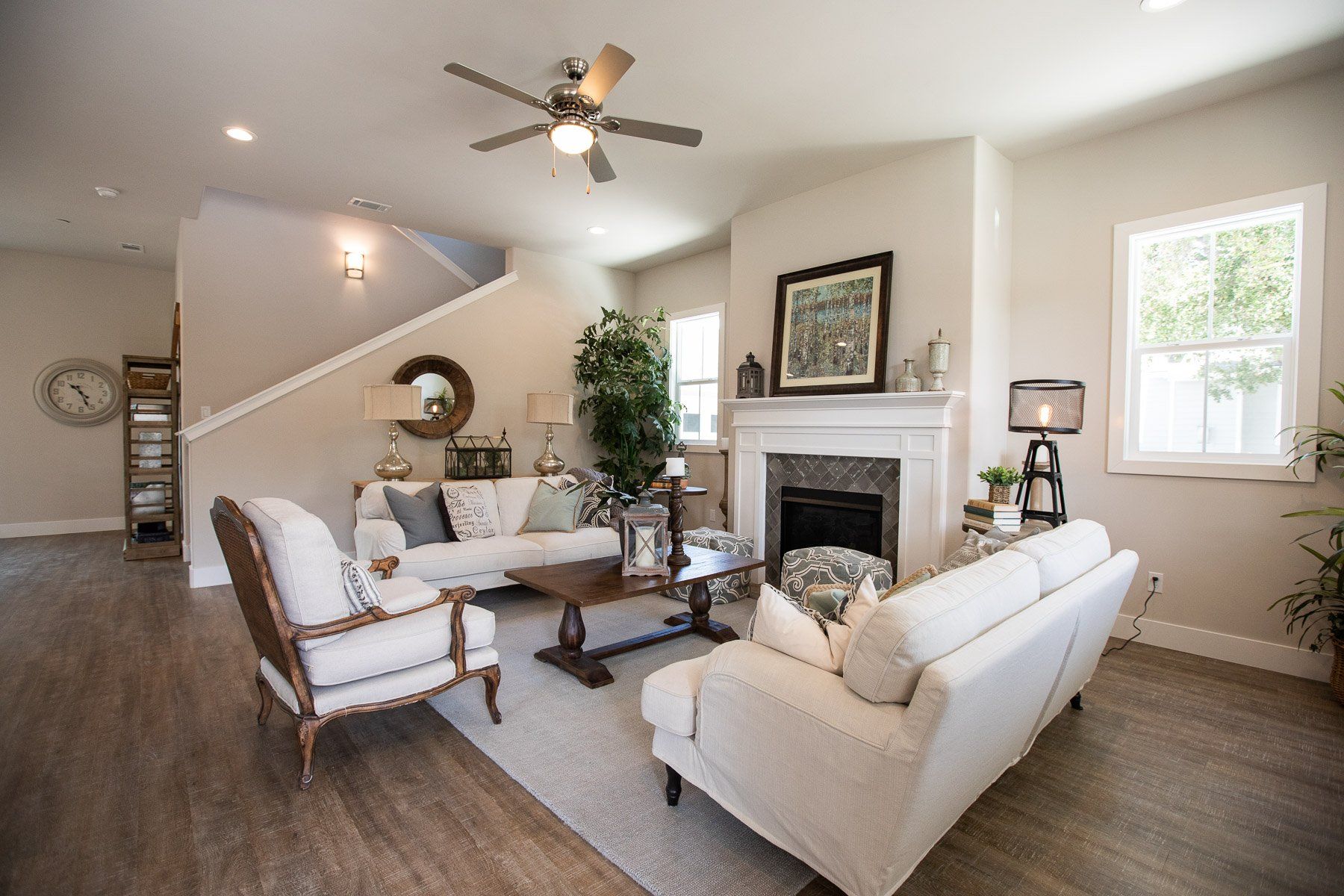 A living room filled with furniture and a fireplace with a ceiling fan.