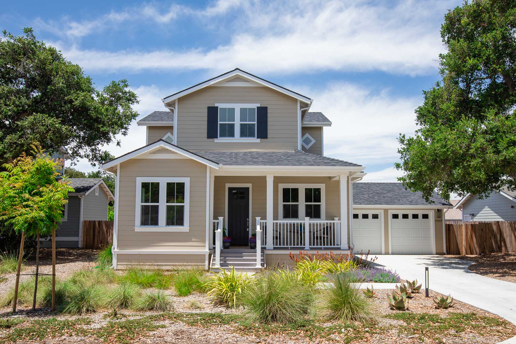 The front of a house with a porch and two garages