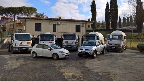 A row of trucks and cars are parked in front of a building