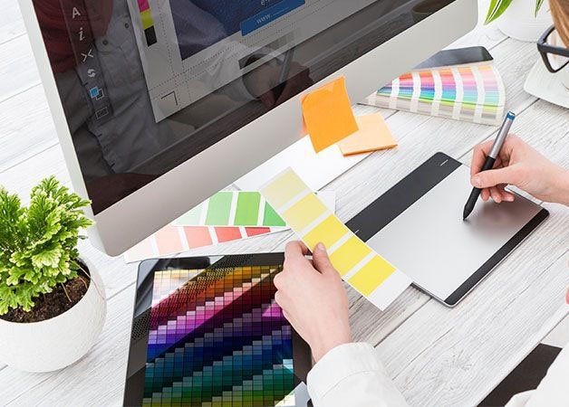 Una persona utilizza una tavoletta grafica davanti a un computer.