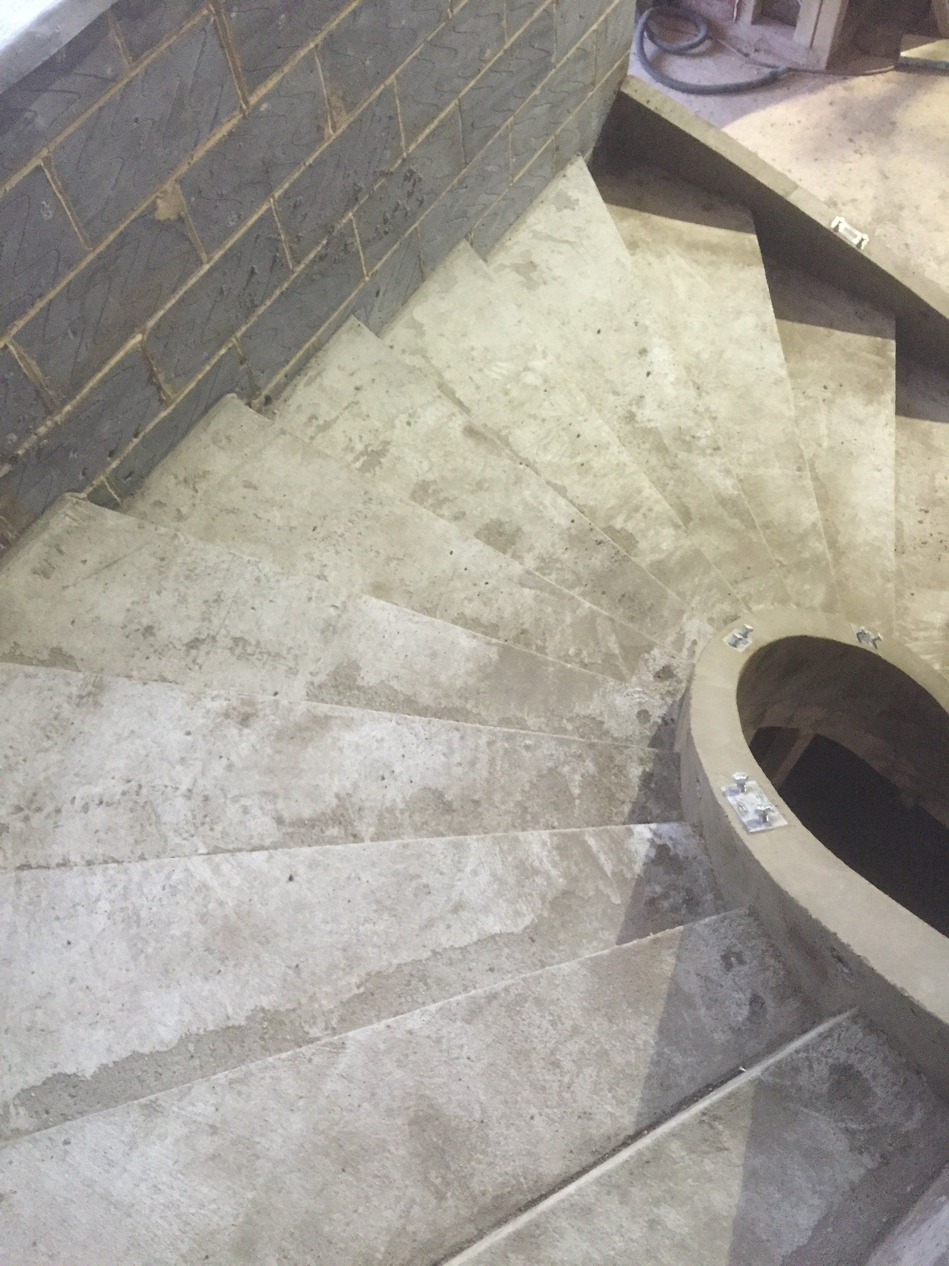 A close up of a spiral staircase with a brick wall in the background.