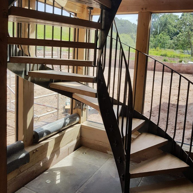 A spiral staircase with wooden steps and a metal railing