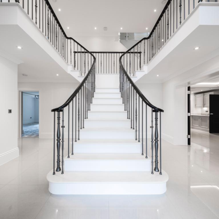 A staircase with white steps and a black railing