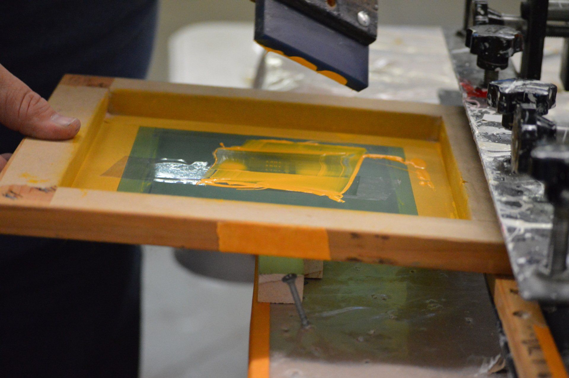 A person is holding a wooden frame with a picture on it.
