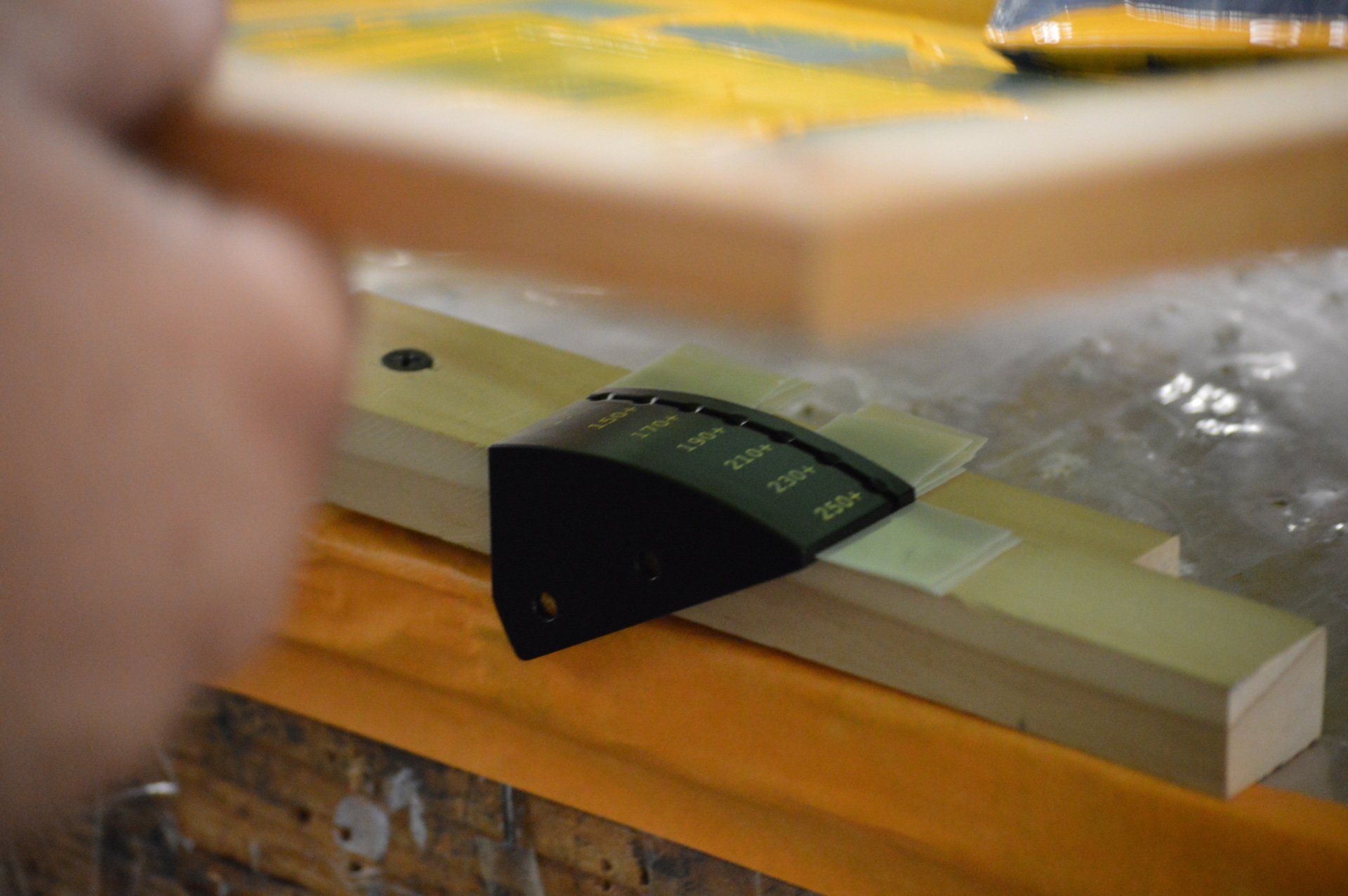 A person is sanding a piece of wood with a sander.
