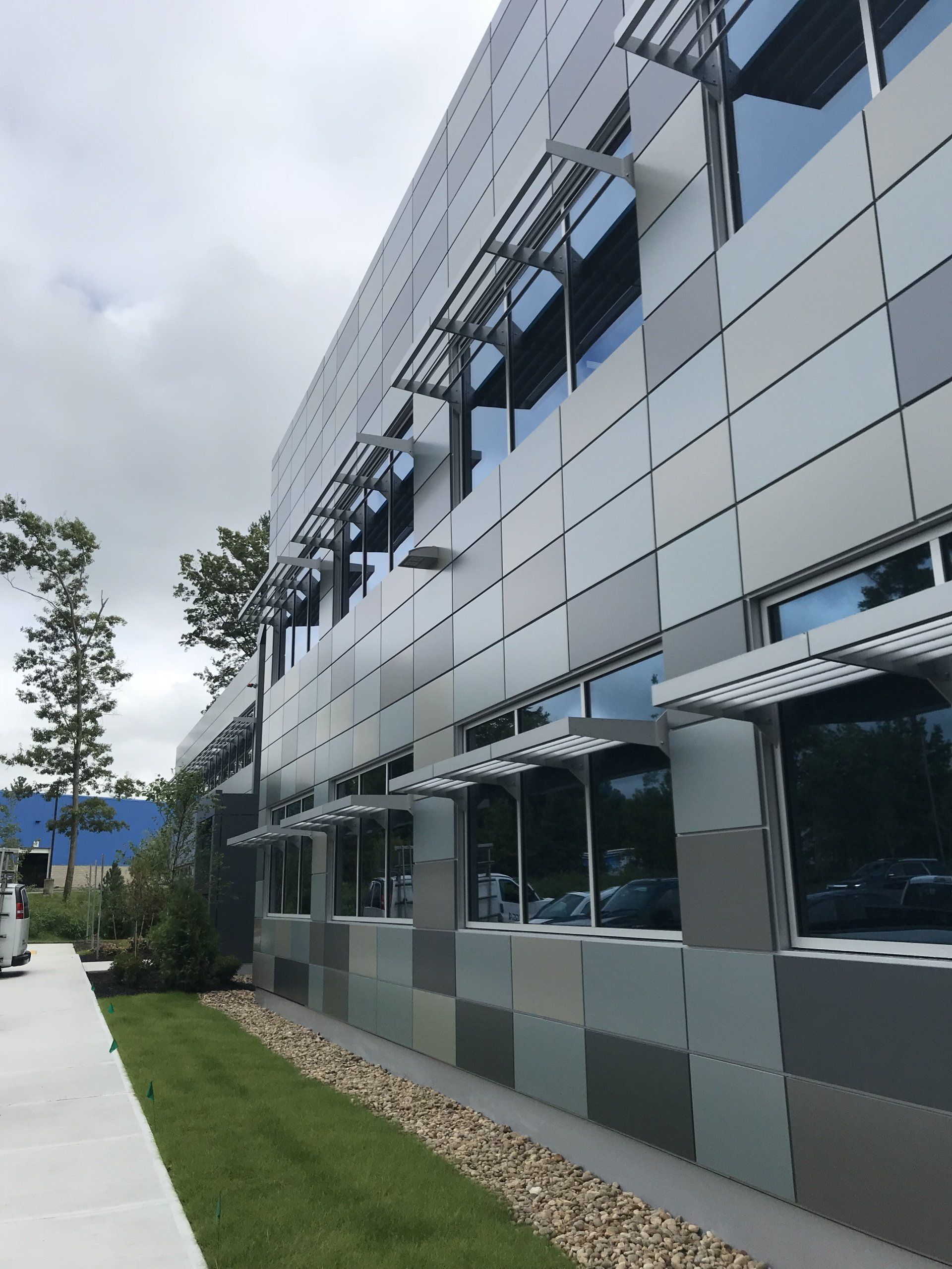 A building with a lot of windows and a sidewalk in front of it