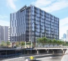 An artist 's impression of a large building next to a highway.