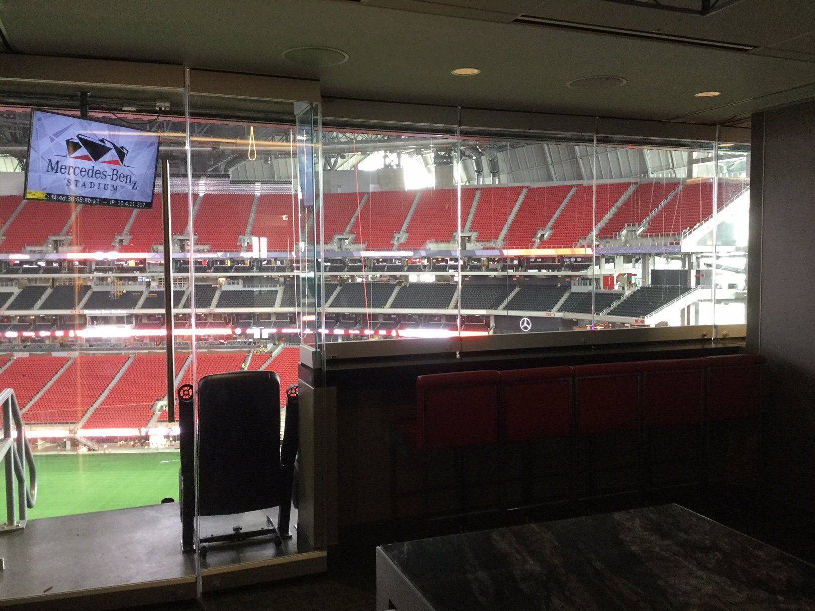 A stadium with a table and chairs and a tv on the wall.