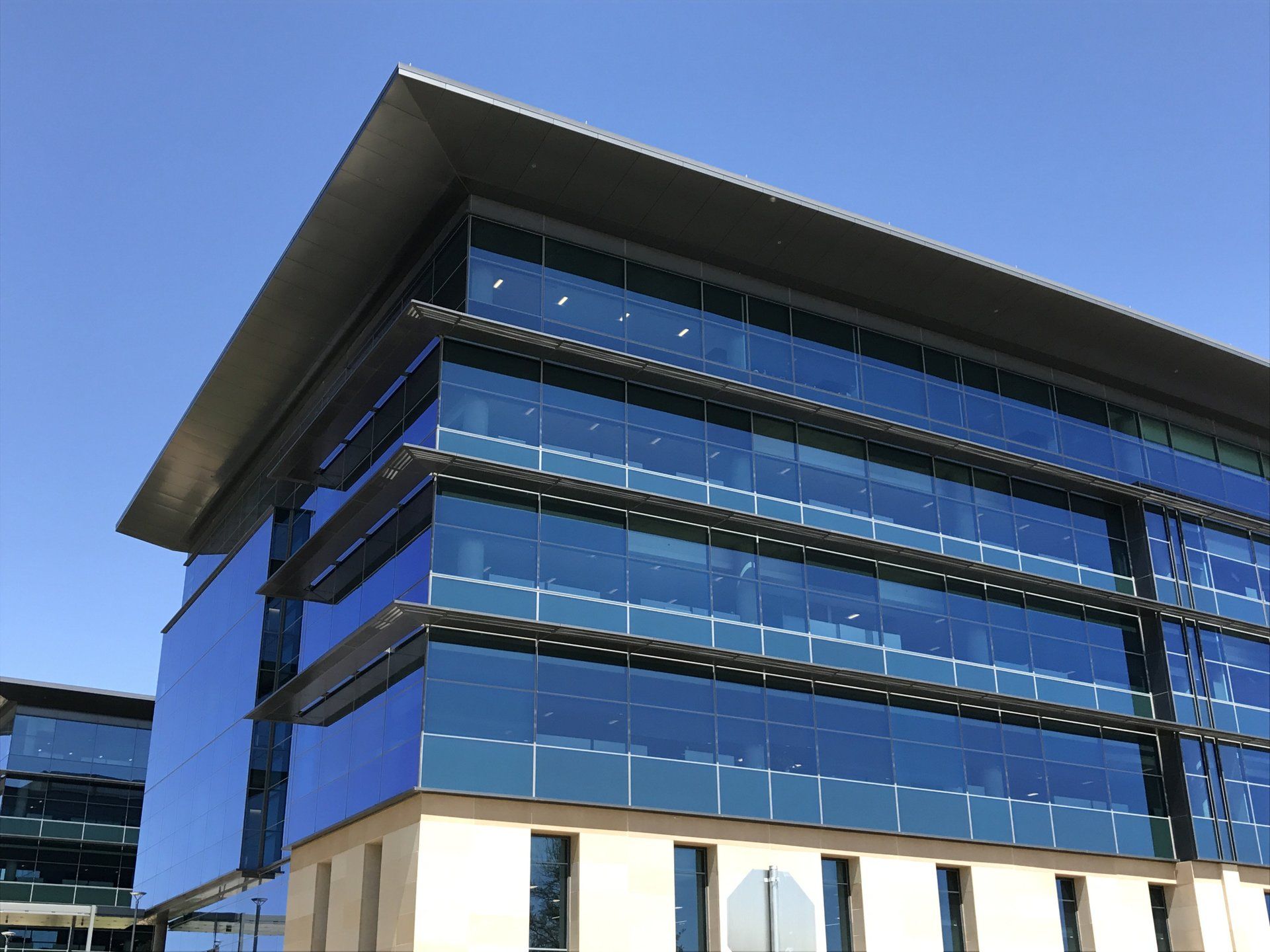 A large building with a lot of windows and a blue sky in the background
