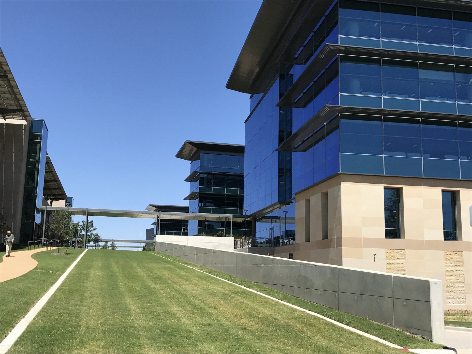 A large building with a lot of windows is next to a smaller building