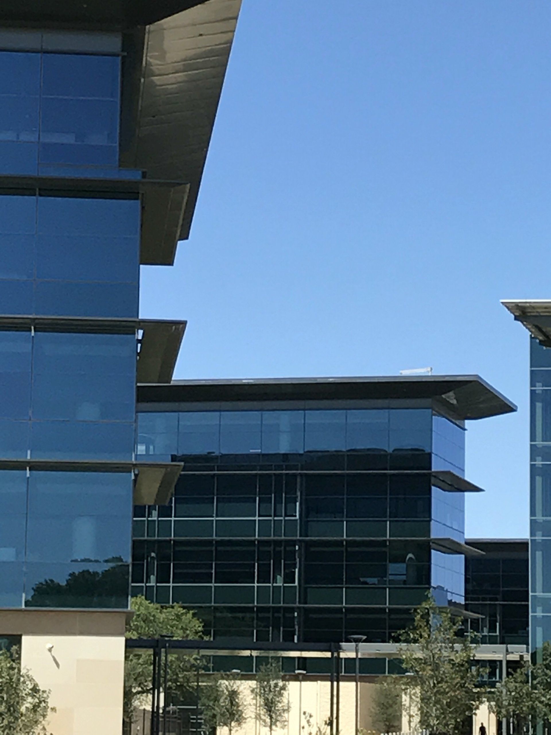 A large glass building with a blue sky in the background