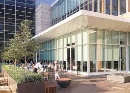 An artist 's impression of a large building with a patio in front of it.