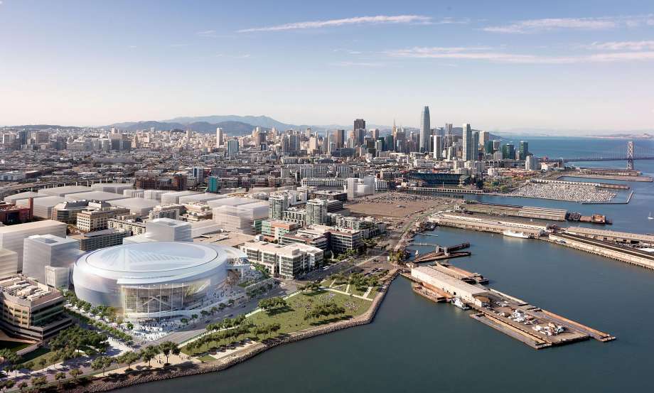 An aerial view of a city with a large stadium in the middle of the city.