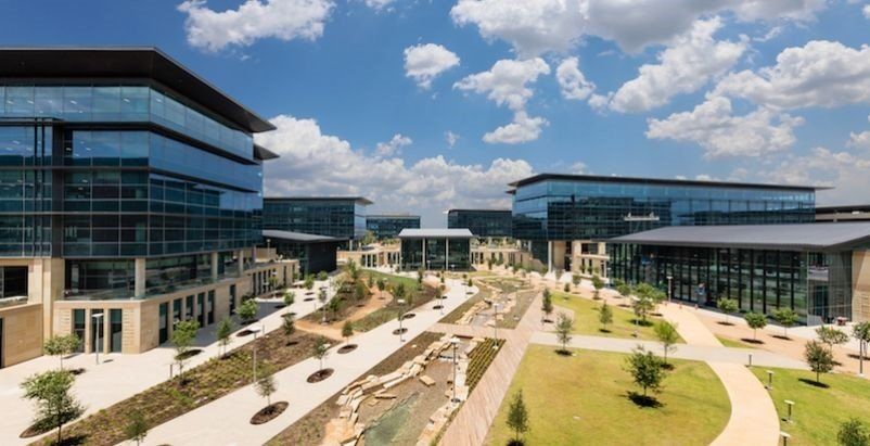 An aerial view of a large business park with lots of buildings and trees.