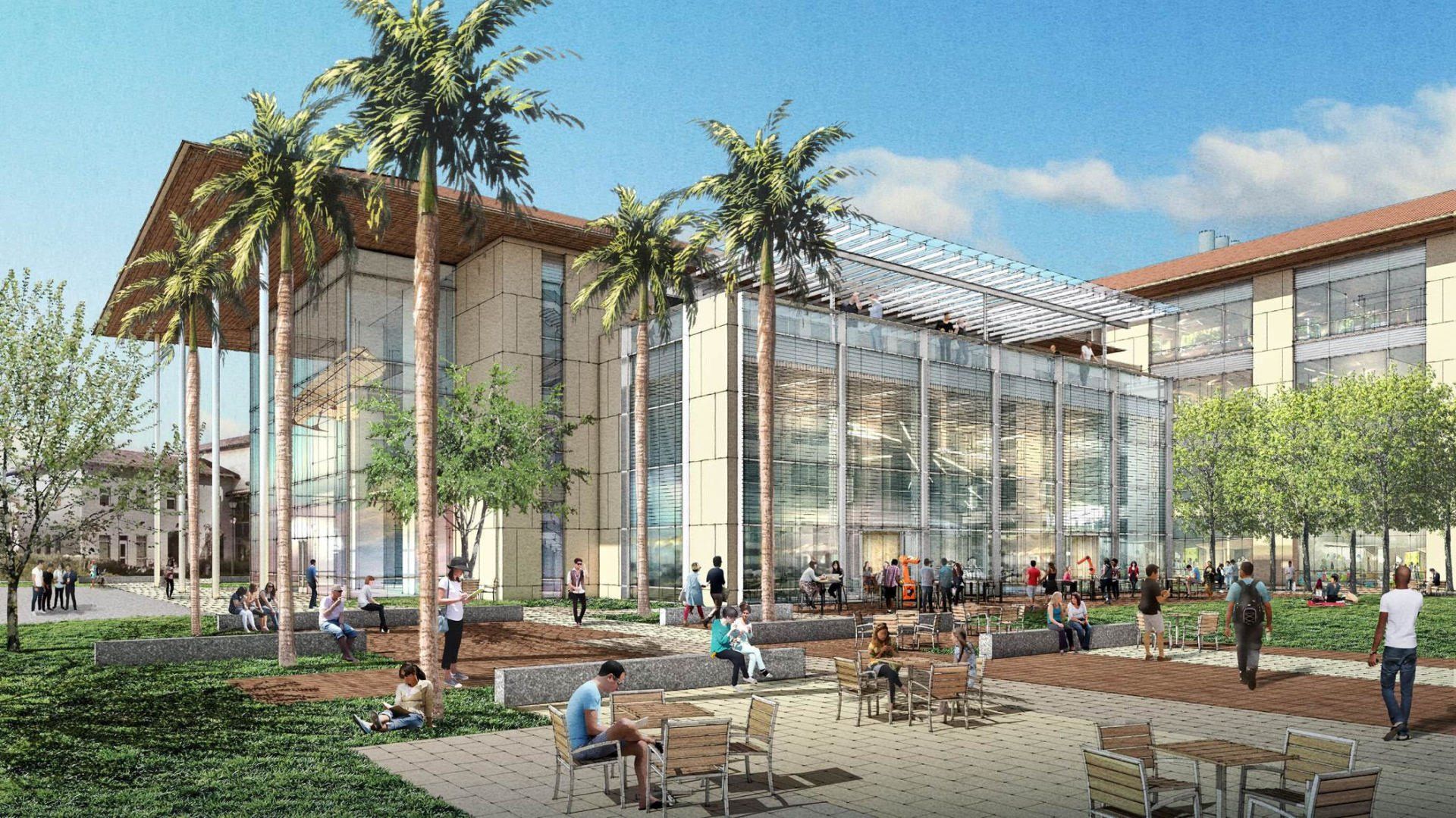A group of people are sitting at tables in front of a large building.