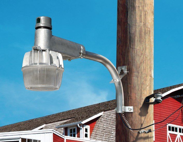 Yard light on utility pole with red barn in background. Yard light on utility pole with red barn in background.