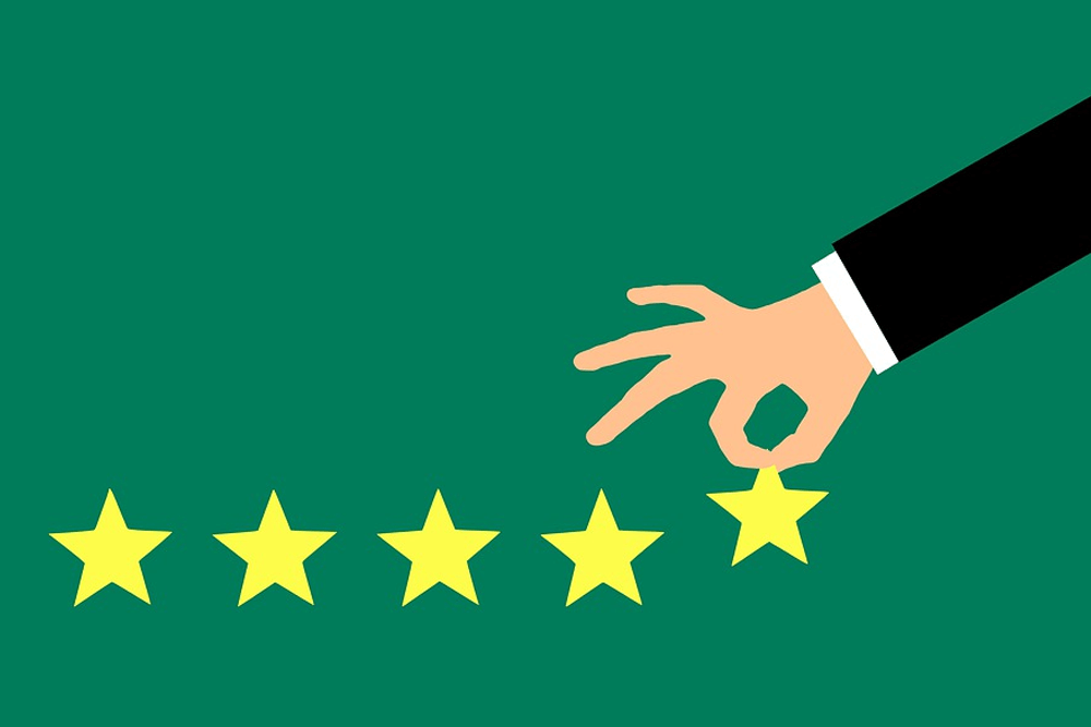 Una mano coloca una quinta estrella amarilla sobre un fondo verde, con cuatro estrellas ya alineadas debajo.